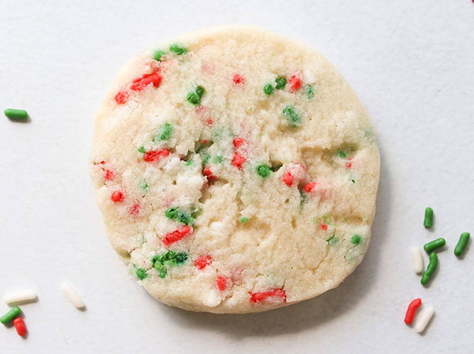 A soft holiday sugar cookie with red and green sprinkles, showcasing a simple and festive treat for the season.